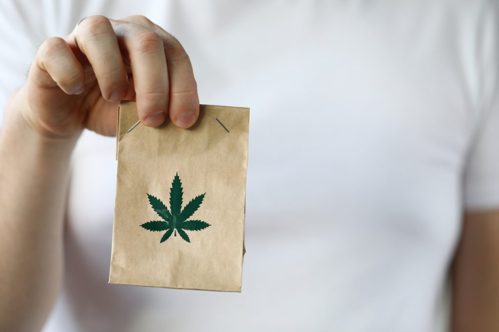 Courier hand passing package with marijuana